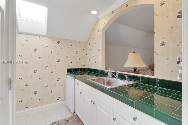 bathroom featuring tile patterned flooring, vanity, and vaulted ceiling