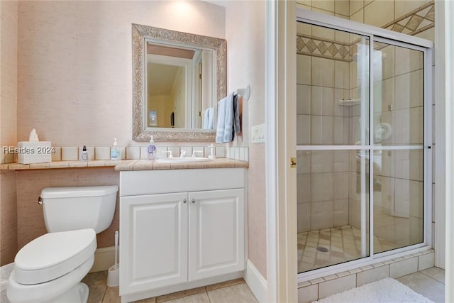 bathroom featuring tile patterned flooring, vanity, an enclosed shower, and toilet