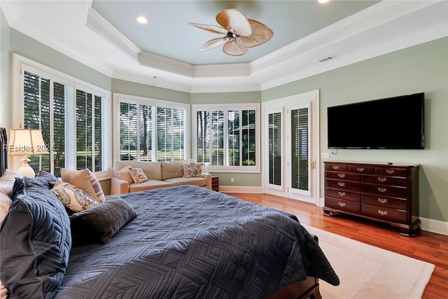 bedroom with access to outside, ornamental molding, a raised ceiling, hardwood / wood-style flooring, and ceiling fan