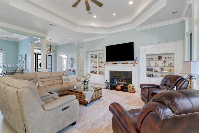 tiled living room featuring decorative columns, ornamental molding, built in features, and a tray ceiling