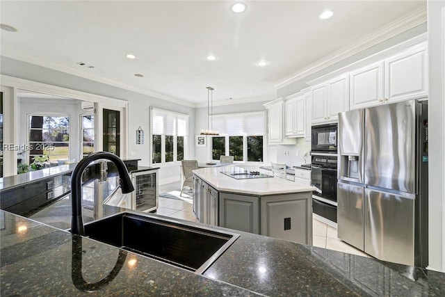 kitchen with sink, decorative light fixtures, a center island, black appliances, and white cabinets