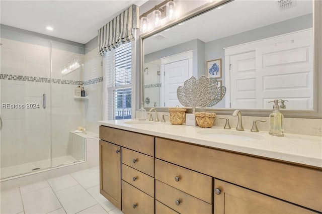 bathroom with a shower with door, vanity, and tile patterned floors