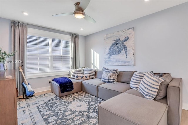 living room with light hardwood / wood-style flooring and ceiling fan