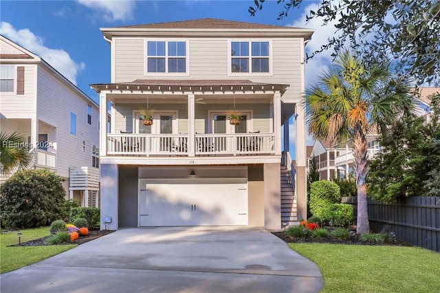 view of front of house featuring a garage, covered porch, and a front lawn