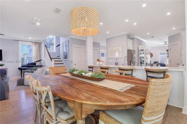 dining room with hardwood / wood-style flooring, an inviting chandelier, and sink