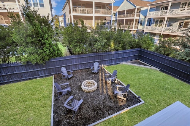 view of home's community with a yard and an outdoor fire pit