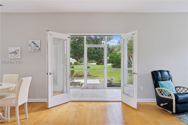 doorway with light hardwood / wood-style floors and french doors