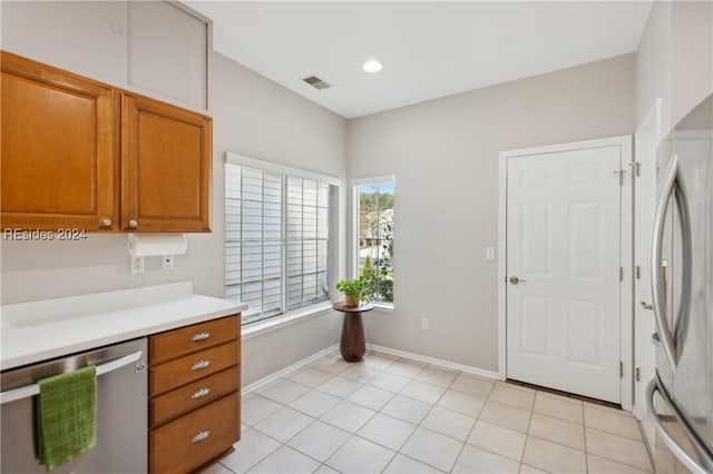 kitchen with appliances with stainless steel finishes, light tile patterned floors, and plenty of natural light