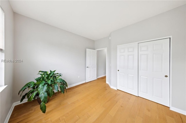 unfurnished bedroom featuring wood-type flooring and a closet