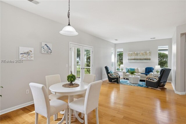 dining space with french doors, a wealth of natural light, and hardwood / wood-style flooring