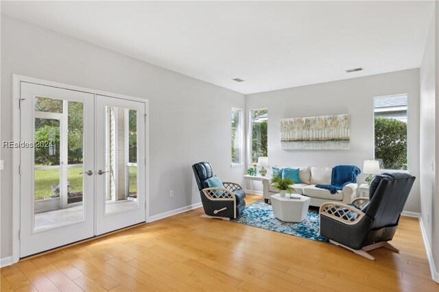 living area featuring wood-type flooring, french doors, and plenty of natural light