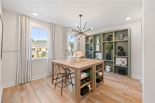 dining area with light hardwood / wood-style floors and a chandelier