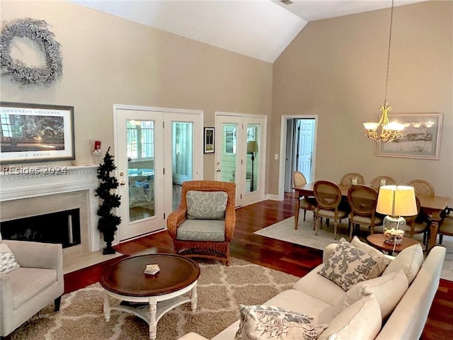 living room with vaulted ceiling, wood-type flooring, and a notable chandelier