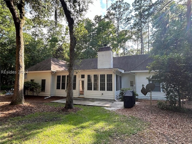 rear view of house featuring a yard and a patio