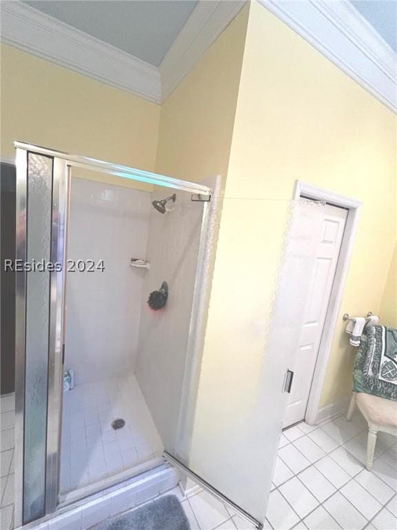 bathroom with tile patterned flooring, a shower with door, and ornamental molding