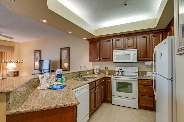 kitchen featuring sink, white appliances, light stone counters, light tile patterned flooring, and kitchen peninsula