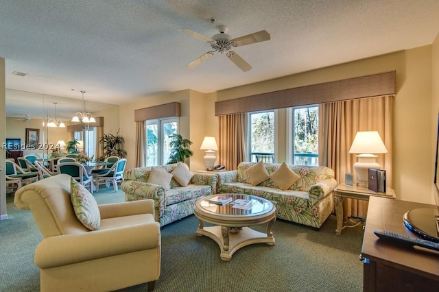 carpeted living room featuring ceiling fan with notable chandelier and a textured ceiling