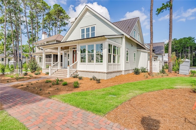 view of front of house featuring covered porch and a front lawn