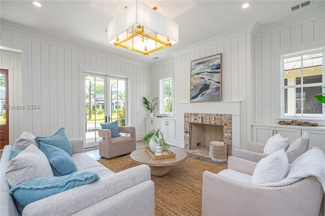 living room with crown molding and a fireplace