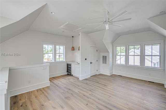 bonus room featuring wine cooler, light hardwood / wood-style floors, and lofted ceiling