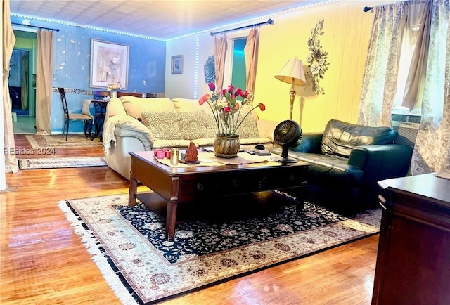 living room with cooling unit, wood-type flooring, and ornamental molding