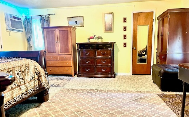 bedroom with a wall mounted air conditioner and light colored carpet