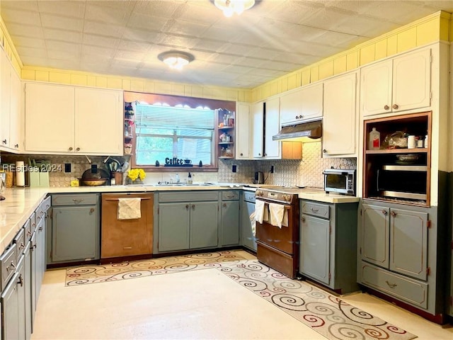 kitchen featuring appliances with stainless steel finishes, tasteful backsplash, white cabinetry, sink, and gray cabinetry