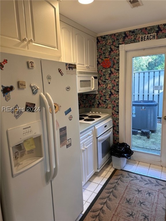 kitchen featuring white cabinetry, light tile patterned floors, and white appliances