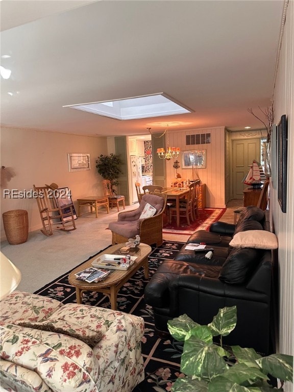 living room featuring carpet, wood walls, and a skylight