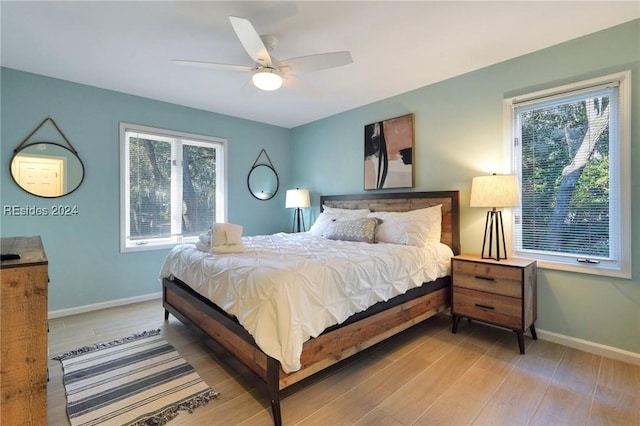 bedroom featuring multiple windows, light wood-type flooring, and ceiling fan