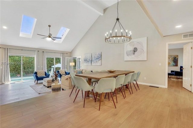 dining space featuring light hardwood / wood-style flooring, an inviting chandelier, a skylight, high vaulted ceiling, and beamed ceiling