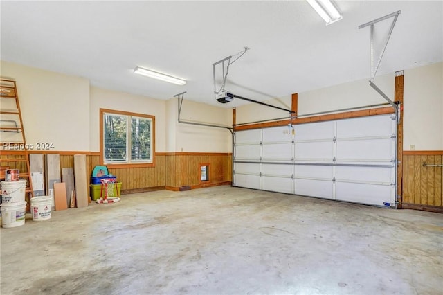 garage featuring a garage door opener and wood walls