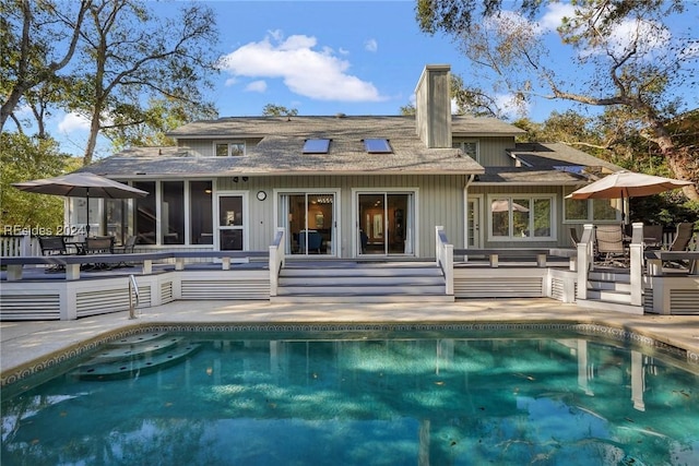 rear view of property with a sunroom and a patio