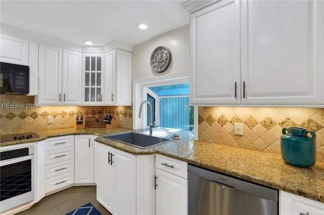 kitchen with white cabinetry, sink, and black appliances