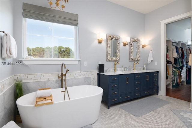 bathroom featuring tile patterned flooring, vanity, a bathtub, and tile walls