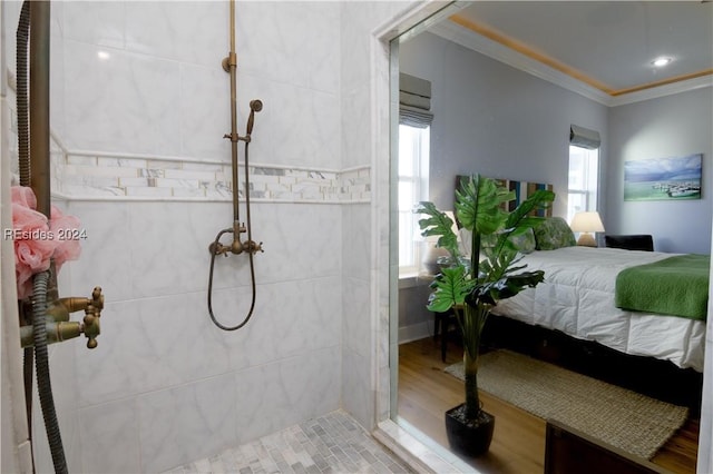 bathroom featuring crown molding, a healthy amount of sunlight, and a tile shower