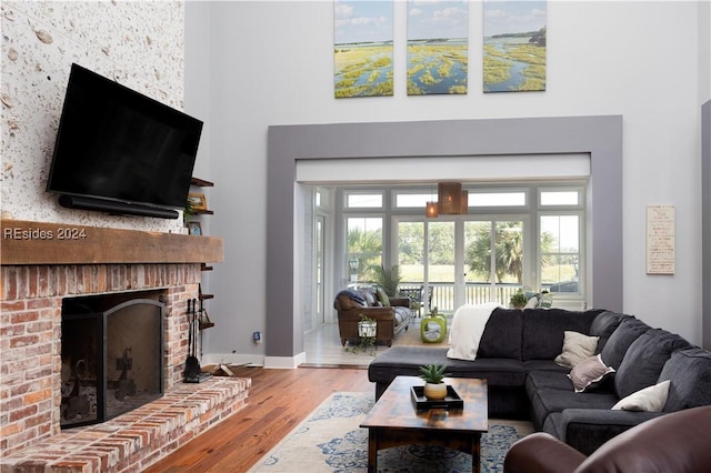 living room with hardwood / wood-style flooring and a brick fireplace