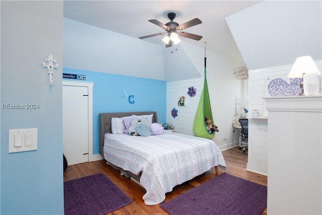 bedroom with hardwood / wood-style flooring, vaulted ceiling, and ceiling fan