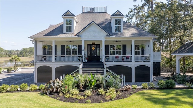 view of front of property with a front yard, ceiling fan, and covered porch