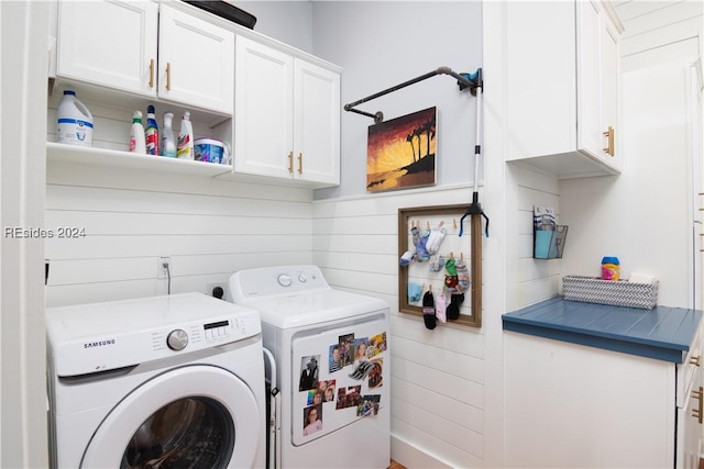 clothes washing area featuring washer and clothes dryer and cabinets