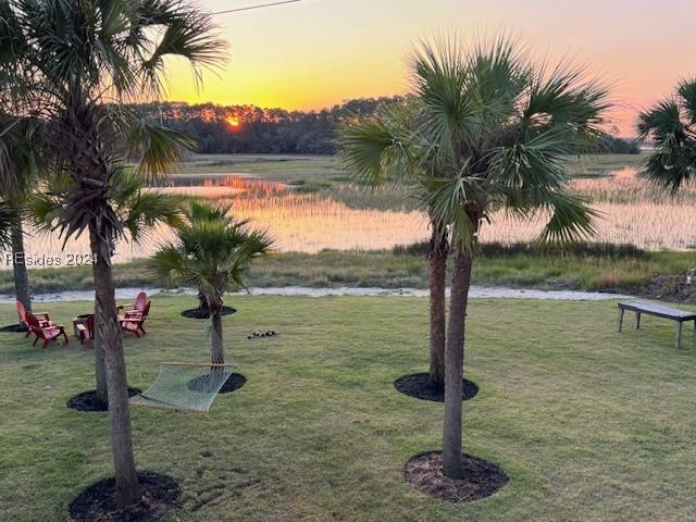 surrounding community featuring a water view and a lawn