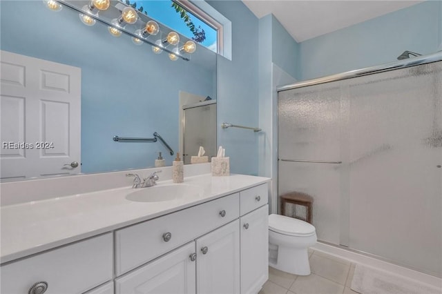 bathroom featuring vanity, a shower with shower door, tile patterned floors, and toilet