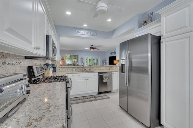 kitchen with tasteful backsplash, sink, stainless steel appliances, and white cabinets