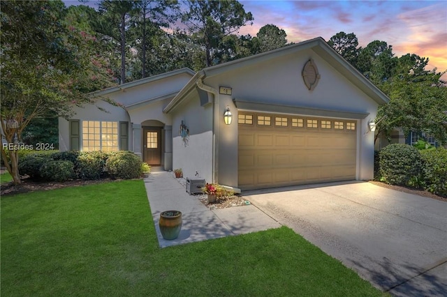 view of front of house with a garage and a yard