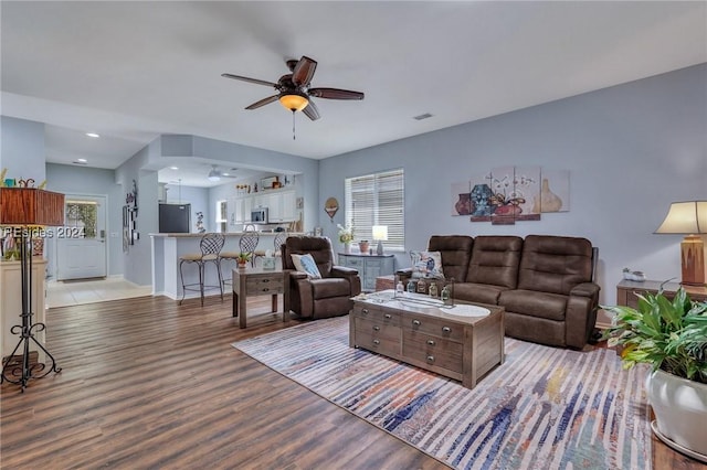 living room featuring light wood-type flooring and ceiling fan