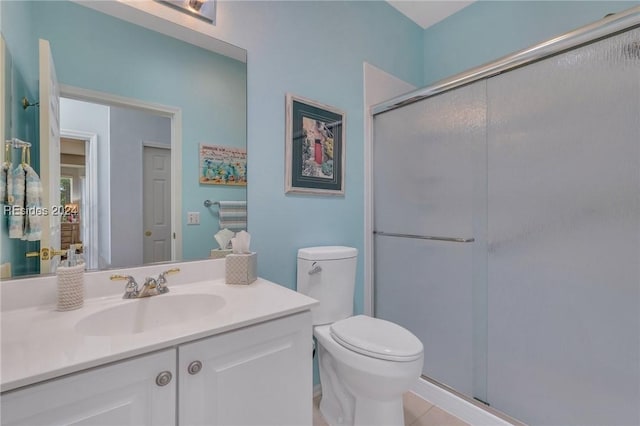 bathroom featuring vanity, walk in shower, tile patterned floors, and toilet