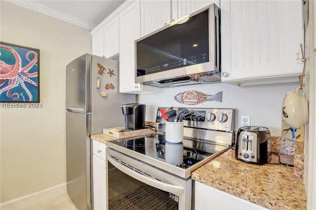 kitchen featuring light tile patterned flooring, white cabinetry, crown molding, light stone counters, and stainless steel appliances