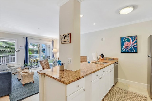 kitchen with sink, white cabinetry, stainless steel appliances, ornamental molding, and light stone countertops