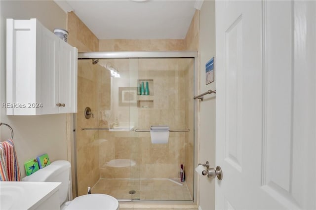 bathroom featuring vanity, an enclosed shower, and toilet