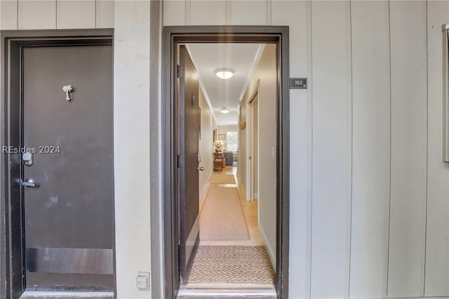 corridor with ornamental molding and light tile patterned flooring